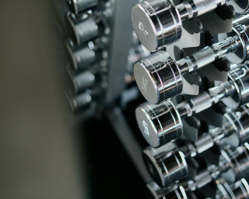 Close up of heavy metal dumbbells on a gym rack