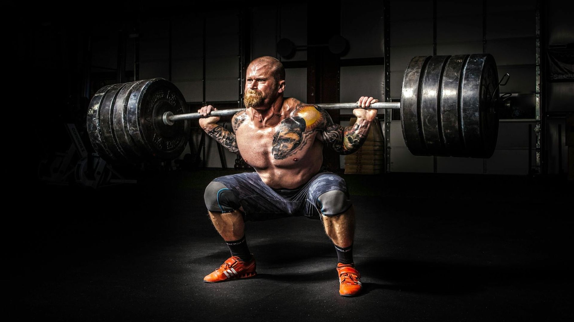 Strong athlete performing a workout in a dark gym setting